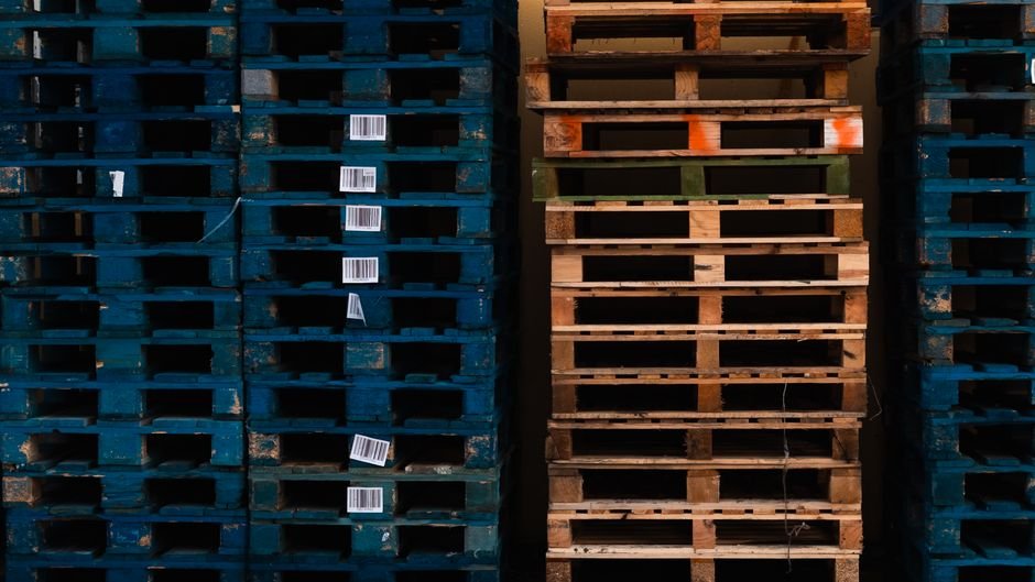Warehouse checker scanning pallet labels during consolidation for China to Belgium commercial pallet shipping